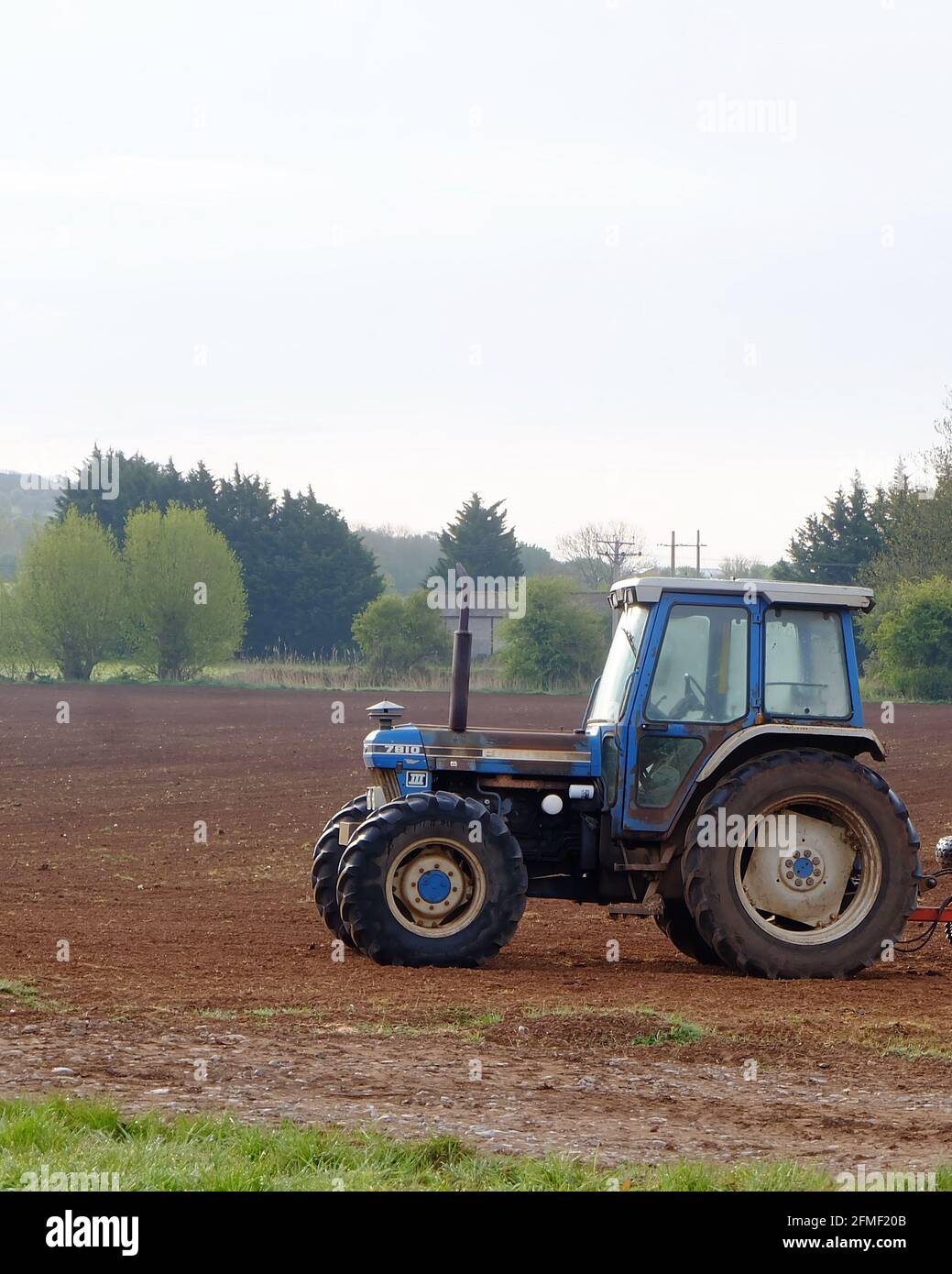 May 2021 - Blue 4x4 New Holland Ford tractor for working the seed bed prior to planting Stock Photo