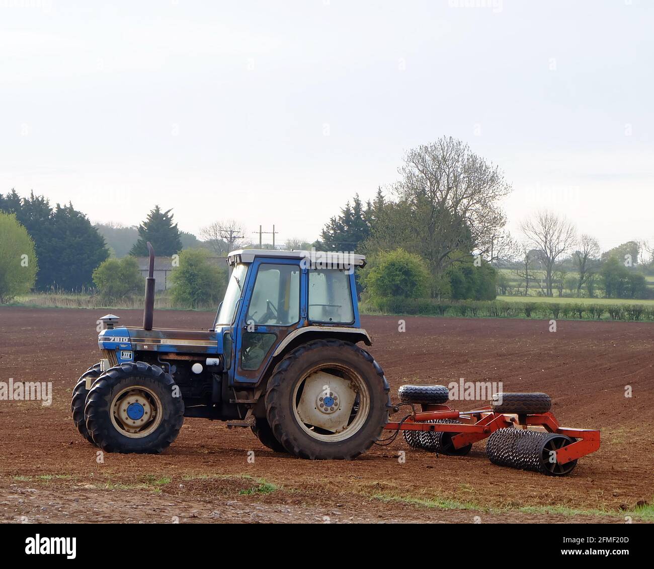 May 2021 - Blue 4x4 New Holland Ford tractor for working the seed bed prior to planting Stock Photo