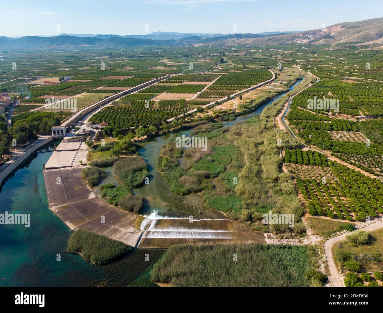 Antella weir in Jucar river (Azud de Antella) surrounded by orange-tree fields in the province of Valencia, Spain Stock Photo