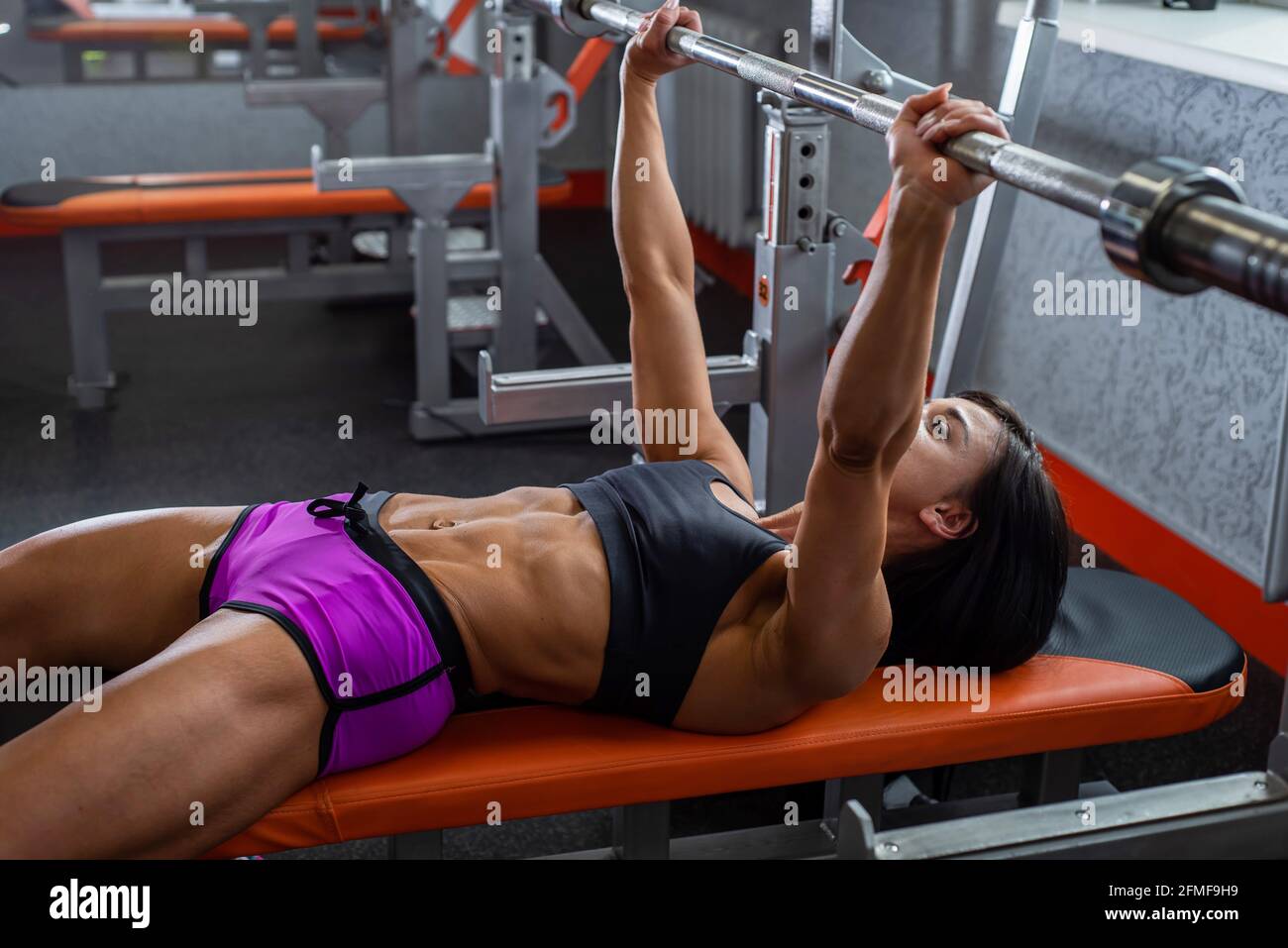 Powerful, strong, muscular girl in short shorts, performs bench press.  Daylight Stock Photo - Alamy