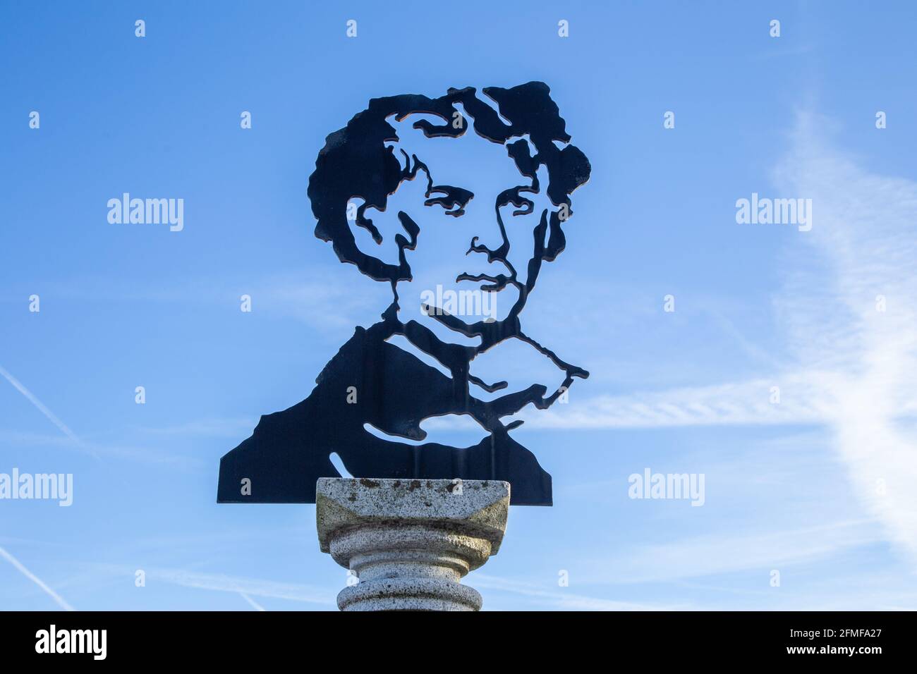 Herrenchiemsee, Germany - 15 December 2019 - Statue of King Ludwig II in paper cutout style portrait displays against blue sky at a boat dock in Herre Stock Photo