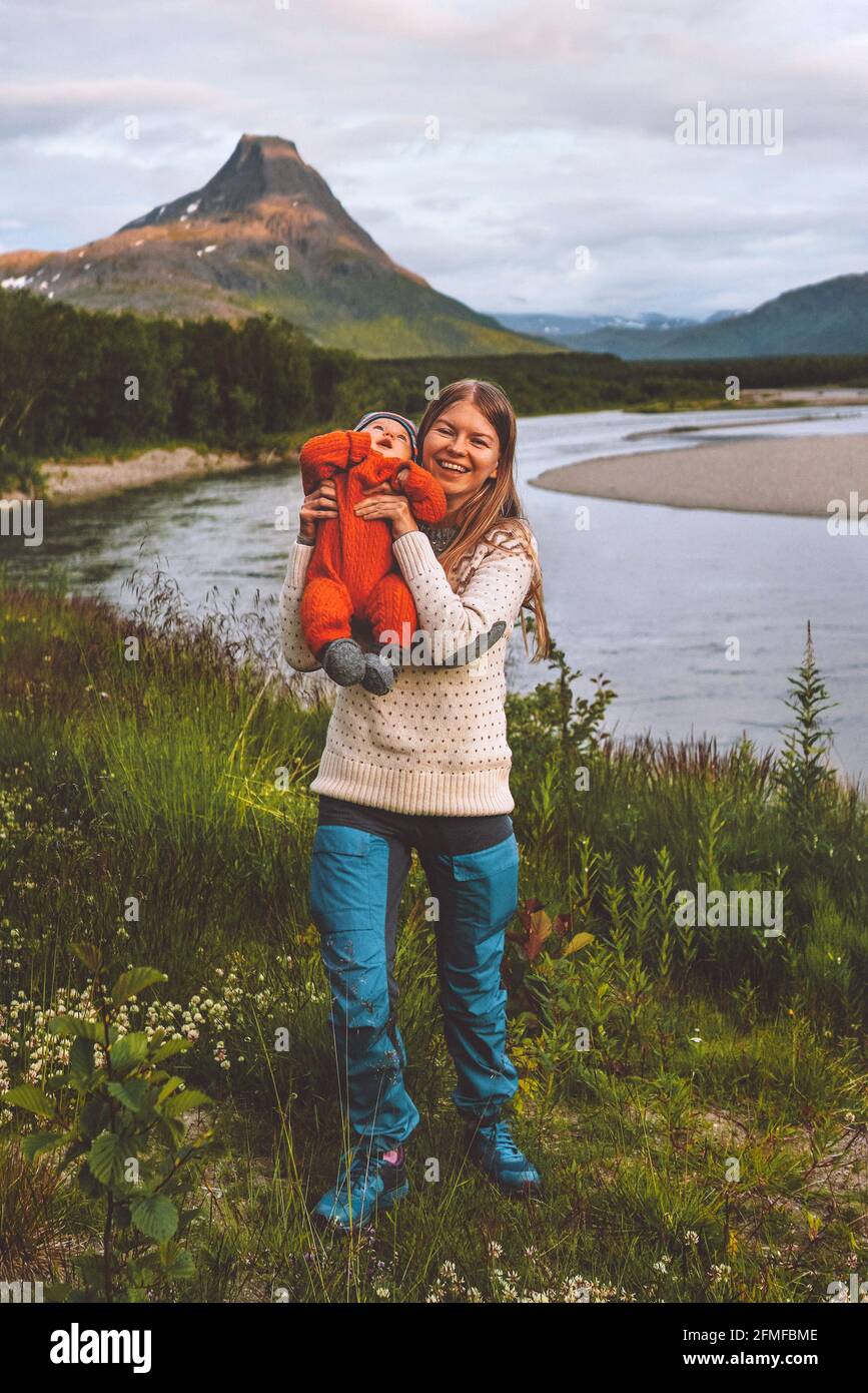 Family mother with infant baby traveling in Norway active vacation mountain and river nature healthy lifestyle outdoor happiness emotions Stock Photo