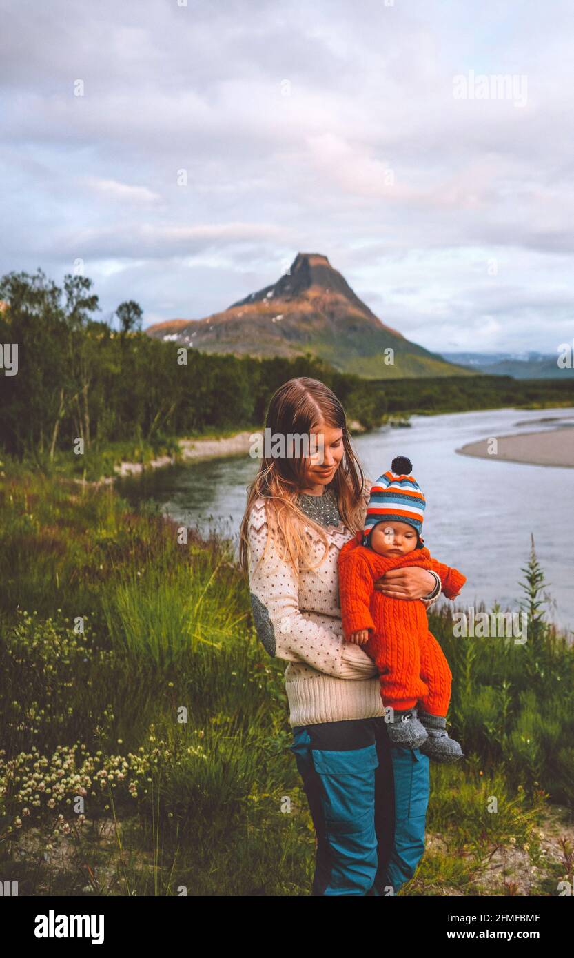 Mother with infant baby outdoor vacations family travel in Norway mountain and river wilderness nature parent and child healthy lifestyle Stock Photo