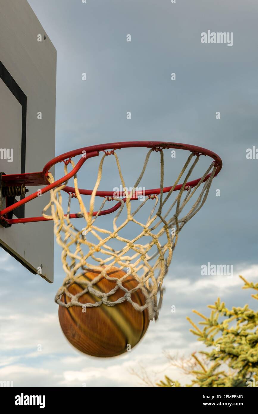 Basketball going through hoop. Goal Stock Photo Alamy