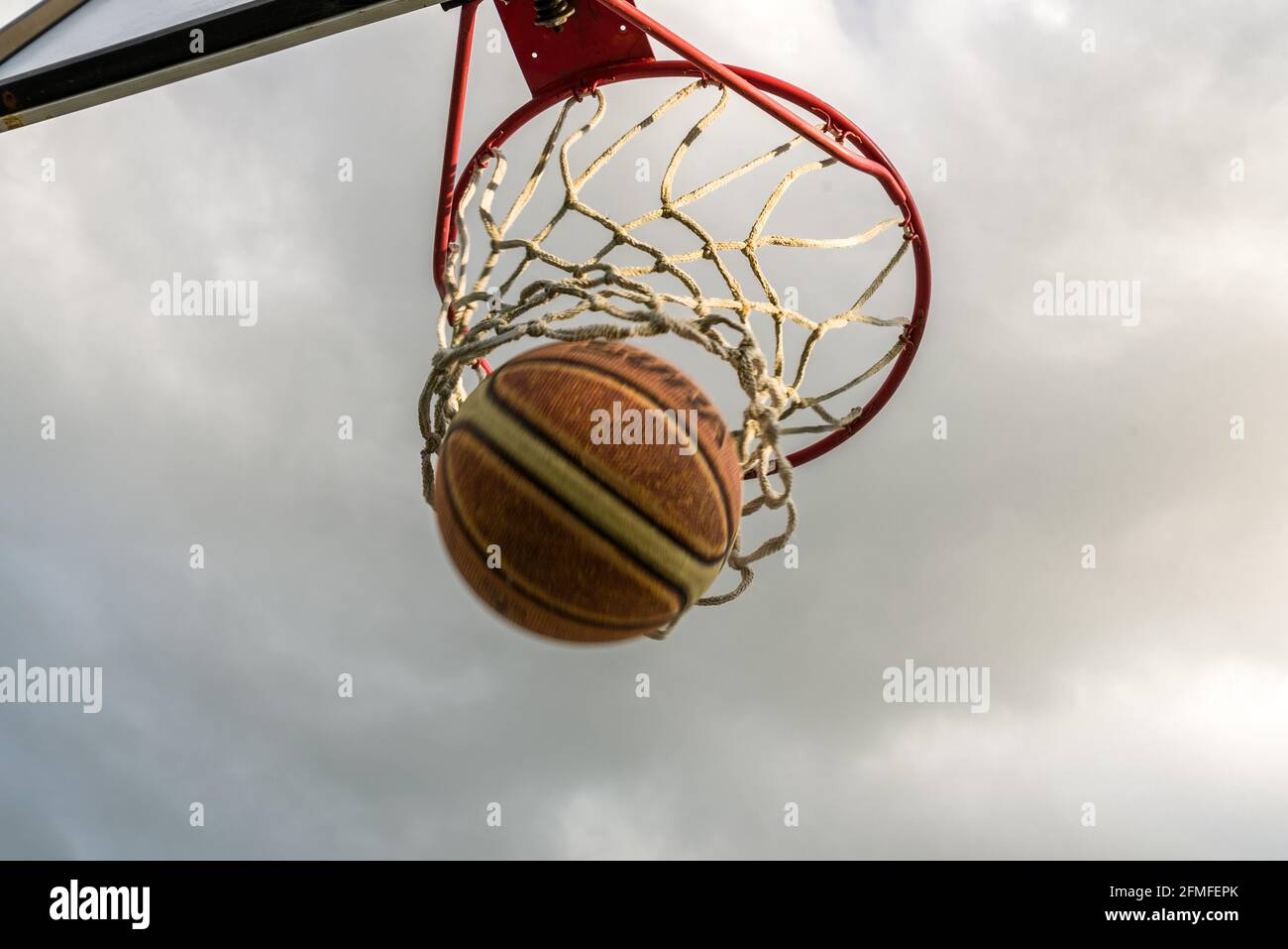 Basketball going through hoop. Goal! Stock Photo Alamy