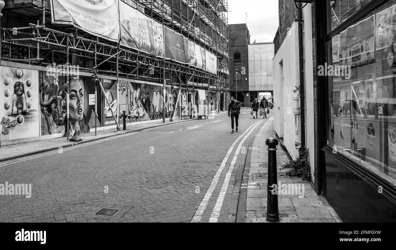 Kingston Upon Thames London, May 07 2021, People  Walking Past A Town Centre Building Or Construction Site Development Covered By Scaffolding And Safe Stock Photo