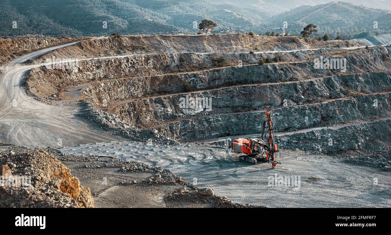Industrial landscape with red stone crusher machine in gravel quarry Stock Photo