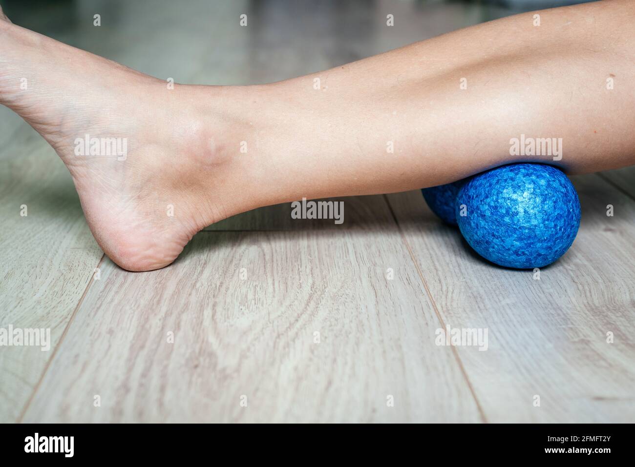 Calf gastrocnemius muscle massage using peanut ball used for muscle soreness relief and