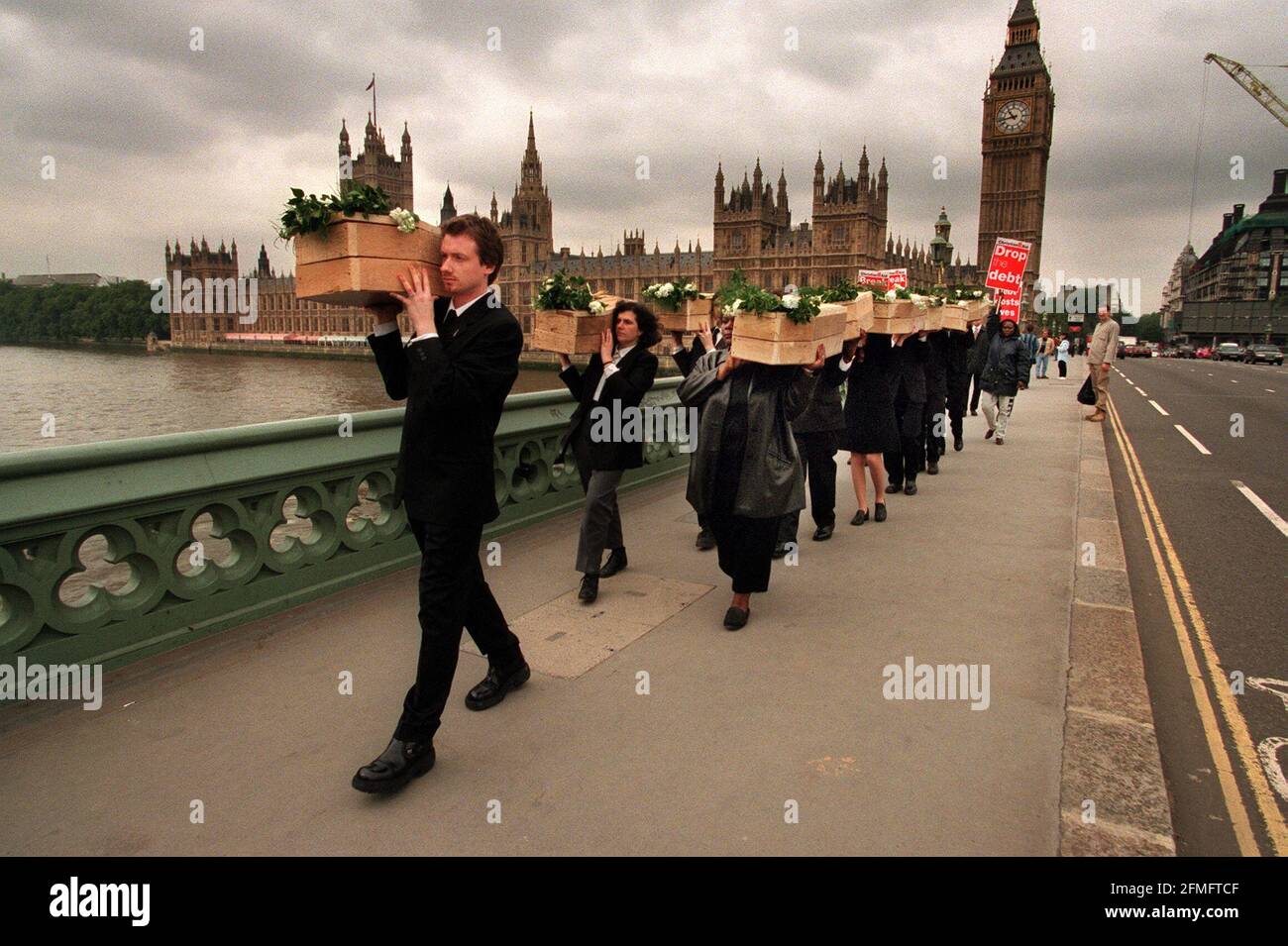 MOCK FUNERAL by CHRISTIAN AID June 1999A MOCK FUNERAL  WITH 13 SMALL COFFINS TO SYMBOLISE THAT 13 CHILDREN DIE EVERY MINUTE IN AFRICA BECAUSE OF DEBT  IS STAGED BY CHRISTIAN AID  ACROSS WESTMINSTER BRIDGE Stock Photo