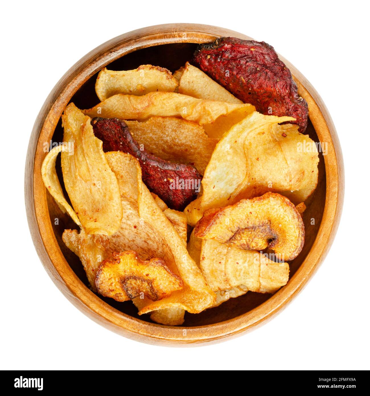 Mixed root vegetable crisps, in a wooden bowl. Mix of sliced root vegetables, parsnips, beetroots and carrots, fried in sunflower oil, with sea salt. Stock Photo