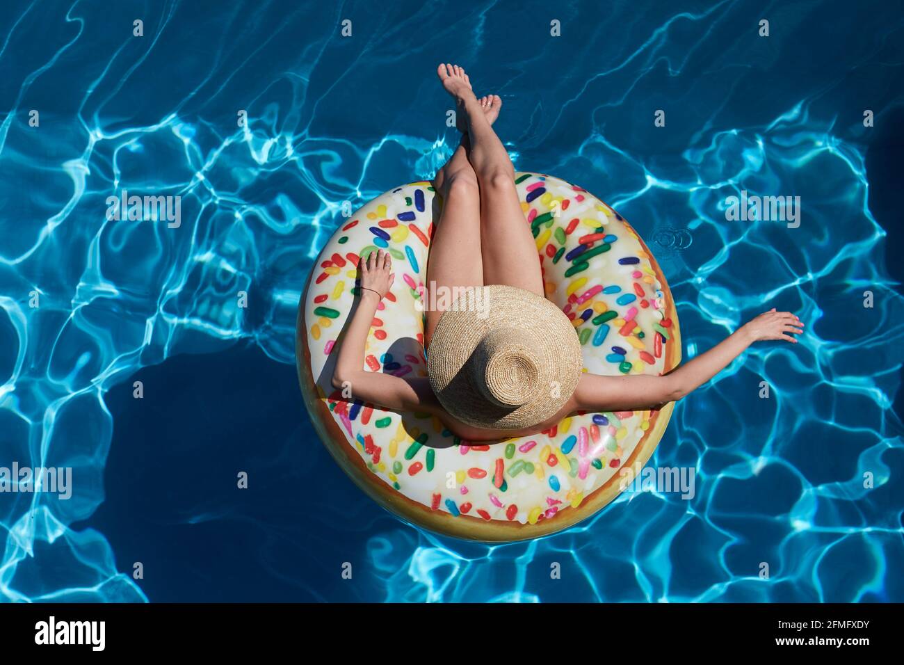 Young woman on inflatable donut ring in pool Stock Photo