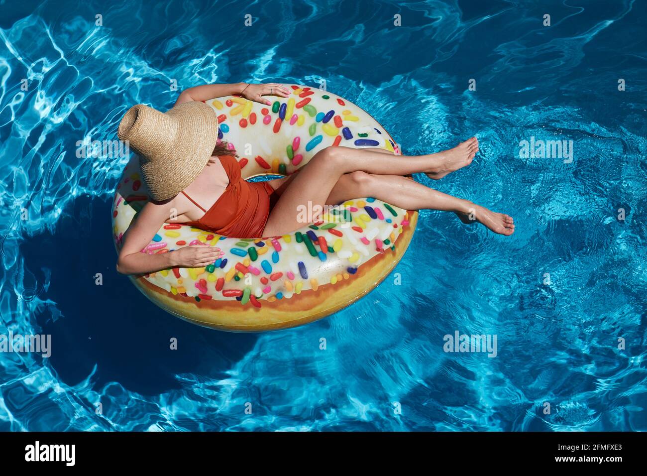 Young woman on inflatable donut ring in pool Stock Photo