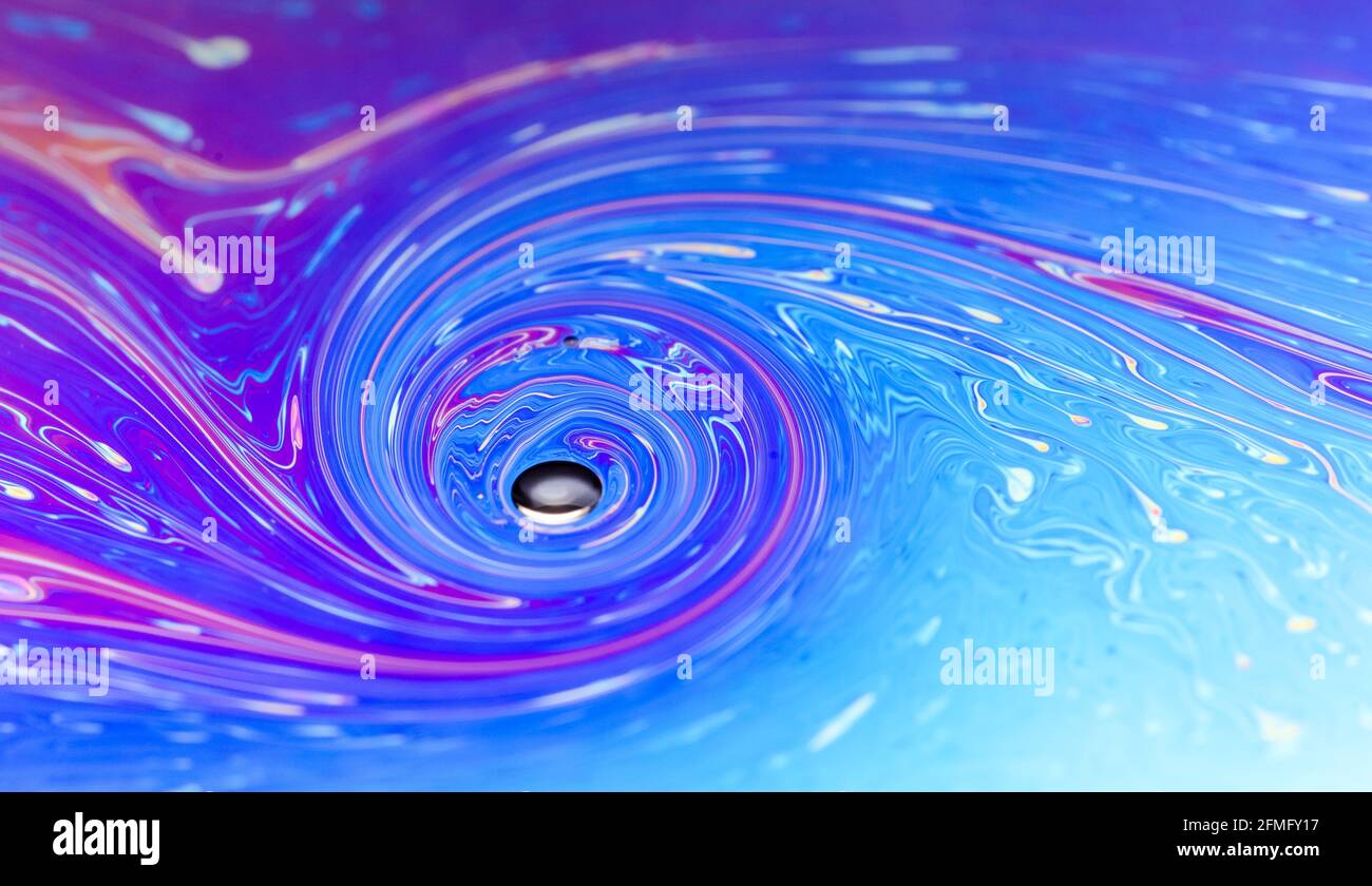 Macro of colorful iridescent flat soap surface with fluid iridescent colors and abstract patterns and shapes, futuristic space art background Stock Photo