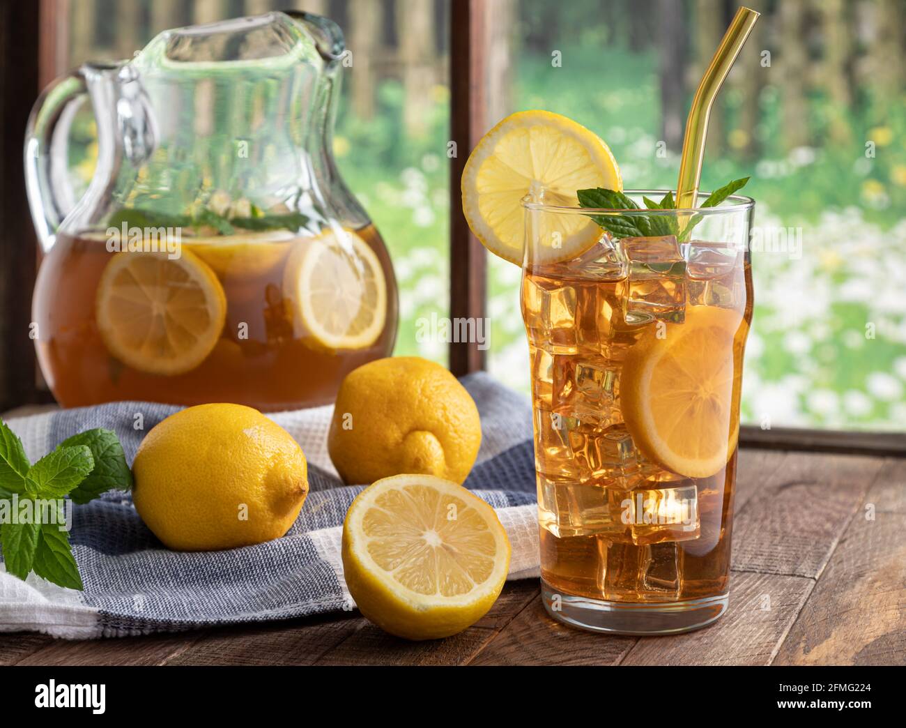 https://c8.alamy.com/comp/2FMG224/glass-of-iced-tea-with-lemon-and-mint-on-a-wooden-table-by-a-window-2FMG224.jpg