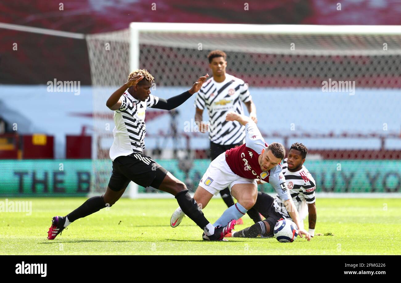 Aston Villa's John McGinn (centre) and Manchester United's Paul Pogba (left) and Manchester United's Fred battle for the ball during the Premier League match at Villa Park, Birmingham. Picture date: Sunday May 9, 2021. Stock Photo