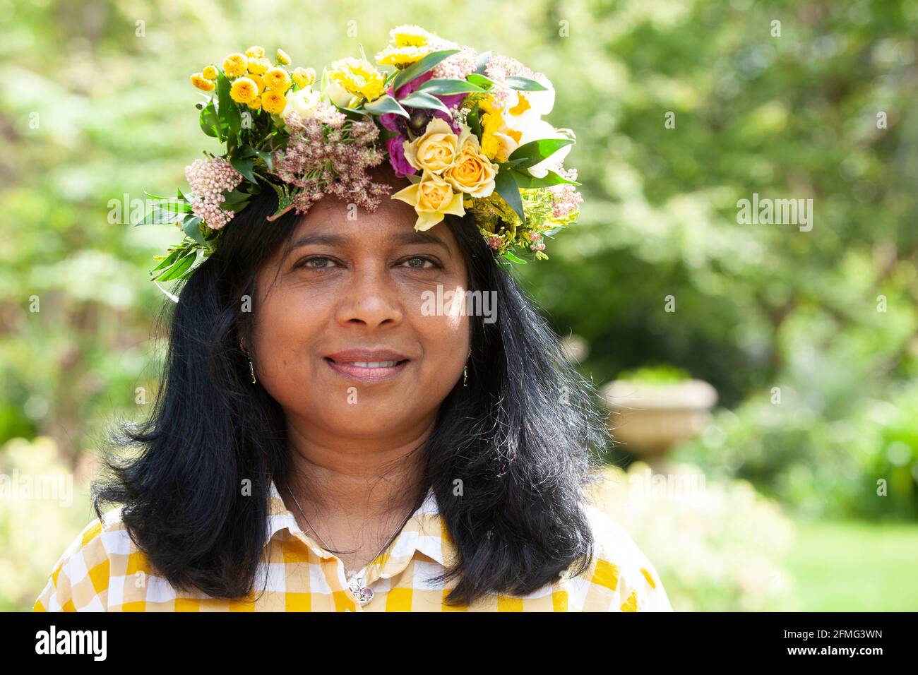 London, UK, 9 May 2021: Bea, an engineer who works in sustainable property  development, poses with the flower crown she made to celebrate Garden Day.  This event was at Chelsea Physic Garden