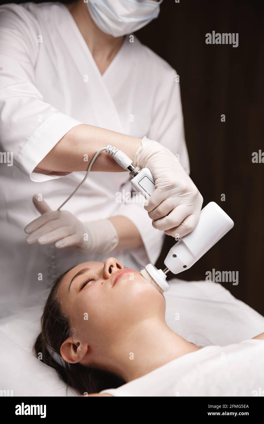 Gentle Exfoliation and Deep Scrubbing. Beauty clinic doctor using brossage facial cleansing brush to remove blemishes and smooth client skin, skincare Stock Photo