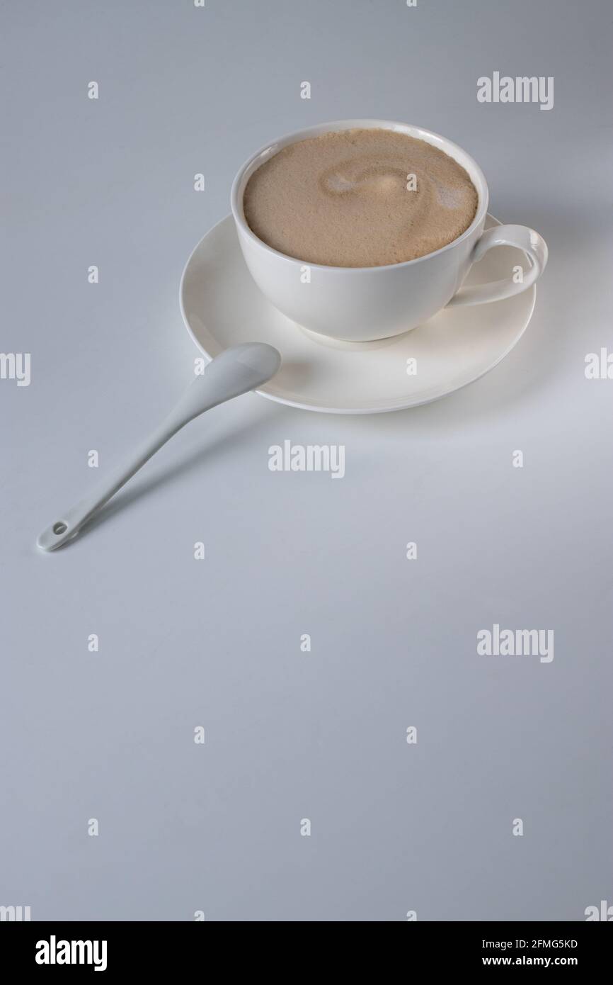 Americano coffee with milk in a white cup and saucer on the table. Morning coffee Stock Photo