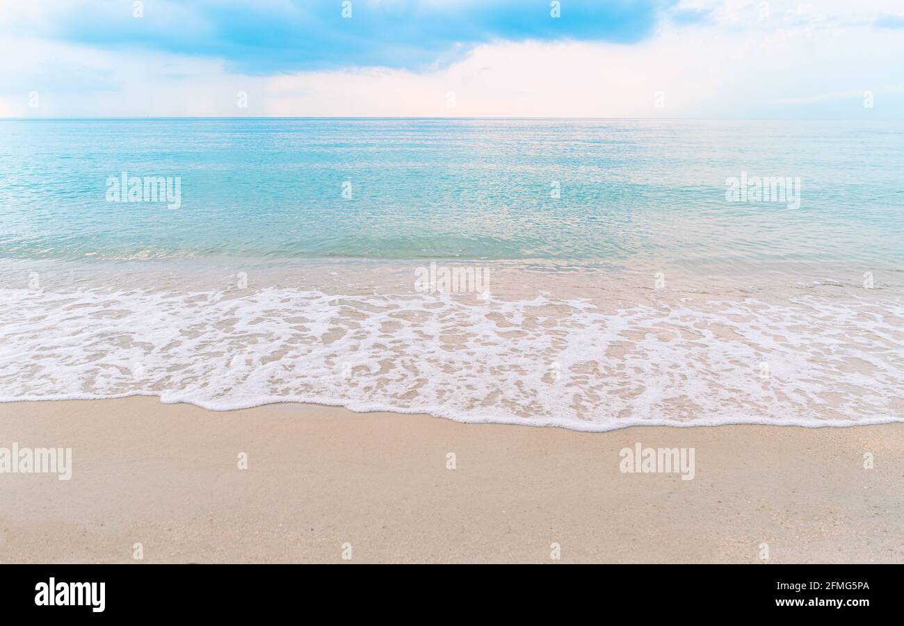Beautiful paradise beachscape, turquoise color water, wave with white bubbles, blue sky with