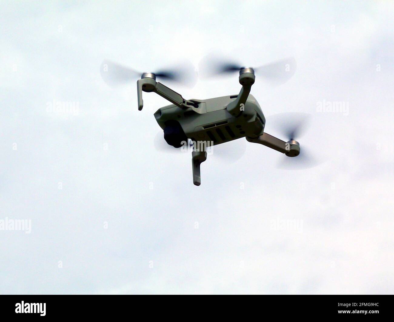 Isolated small drone with camera hovering in the air blue and gray