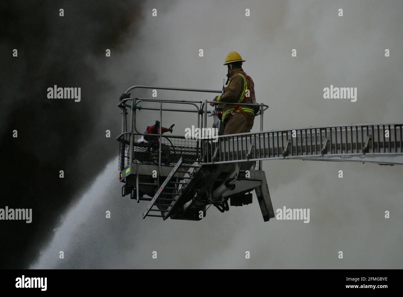Burning building in Ayr, Ayrshire, Scotland, UK. Scottish Fire & rescue  Firefighters using  turntable ladder to fight fire in the roof of a burning building Stock Photo