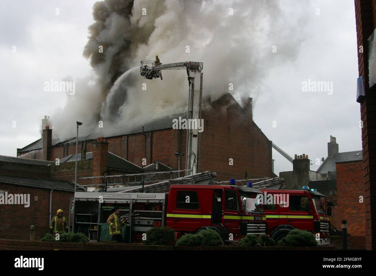 Burning building in Ayr, Ayrshire, Scotland, UK. Scottish Fire & rescue  Firefighters using  turntable ladder to fight fire in the roof of a burning building Stock Photo