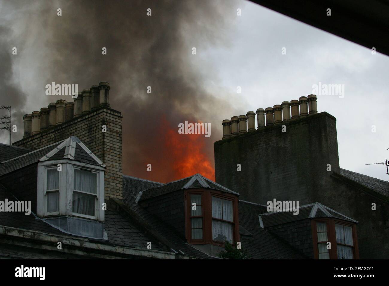 Burning building in Ayr, Ayrshire, Scotland, UK. Scottish Fire & rescue  Firefighters using  turntable ladder to fight fire in the roof of a burning building Stock Photo