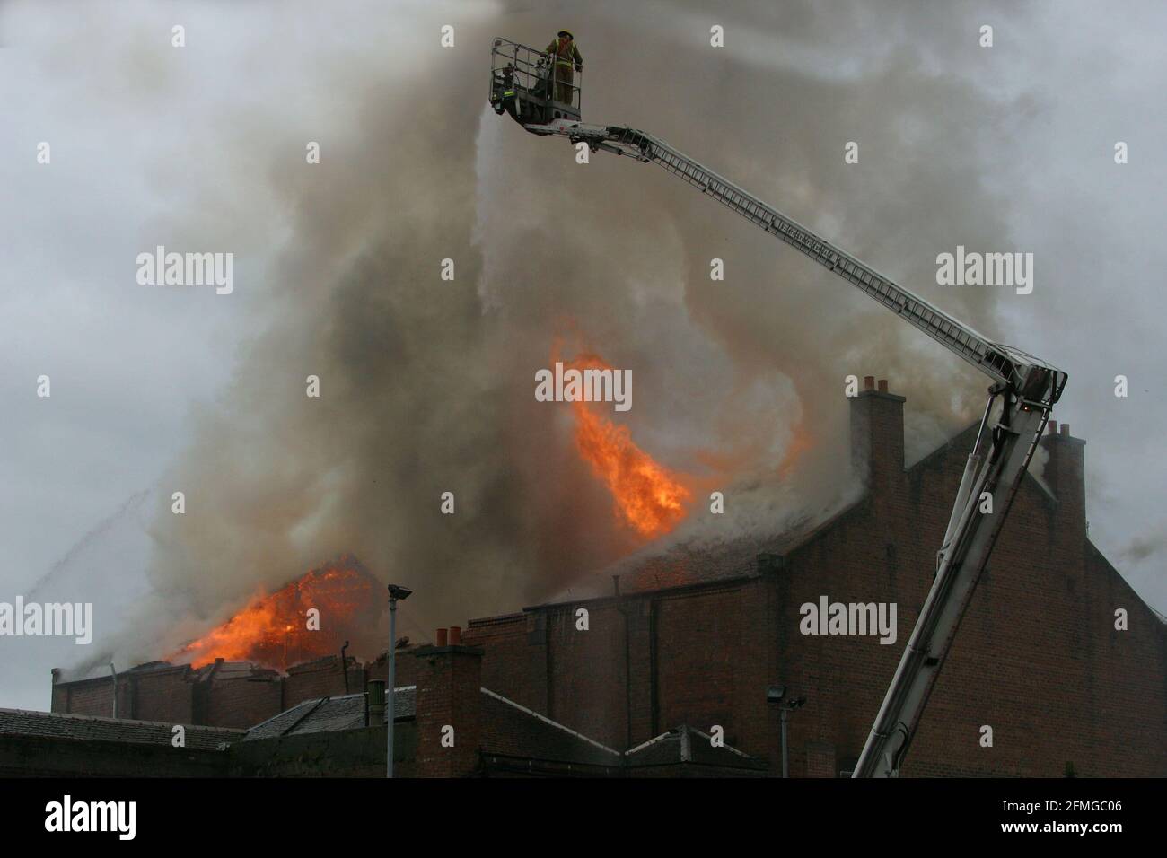 Burning building in Ayr, Ayrshire, Scotland, UK. Scottish Fire & rescue  Firefighters using  turntable ladder to fight fire in the roof of a burning building Stock Photo