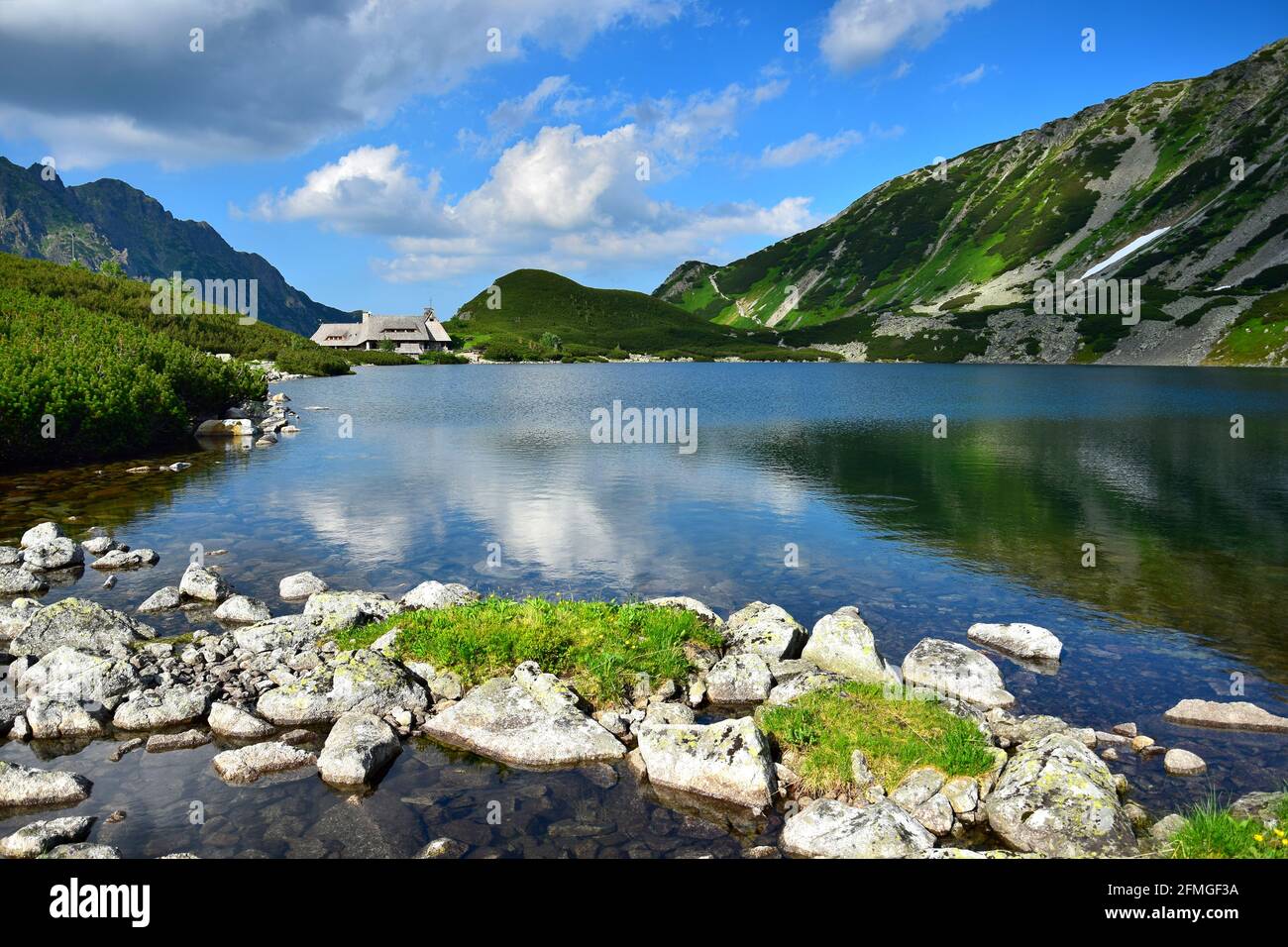 The beautiful lake Przedni Staw and the mountain lodge Schronisko Piec Stawow in the High Tatras, Poland. Stock Photo