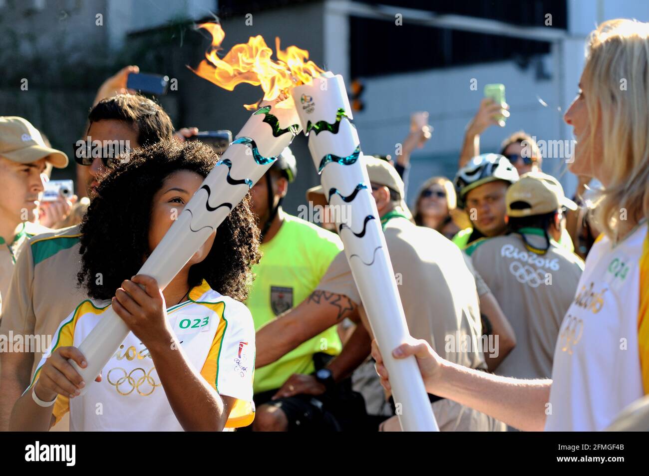 Brazil – August 5, 2016: Torchbearers set fire Olympic flame during the final hours of 2016 Olympic Torch Relay held in Rio de Janeiro's South Zone. Stock Photo