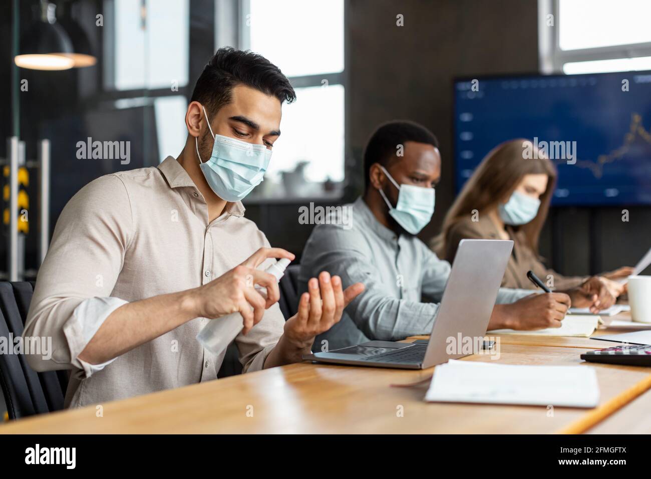 International workers wearing medical masks using sanitizer Stock Photo ...