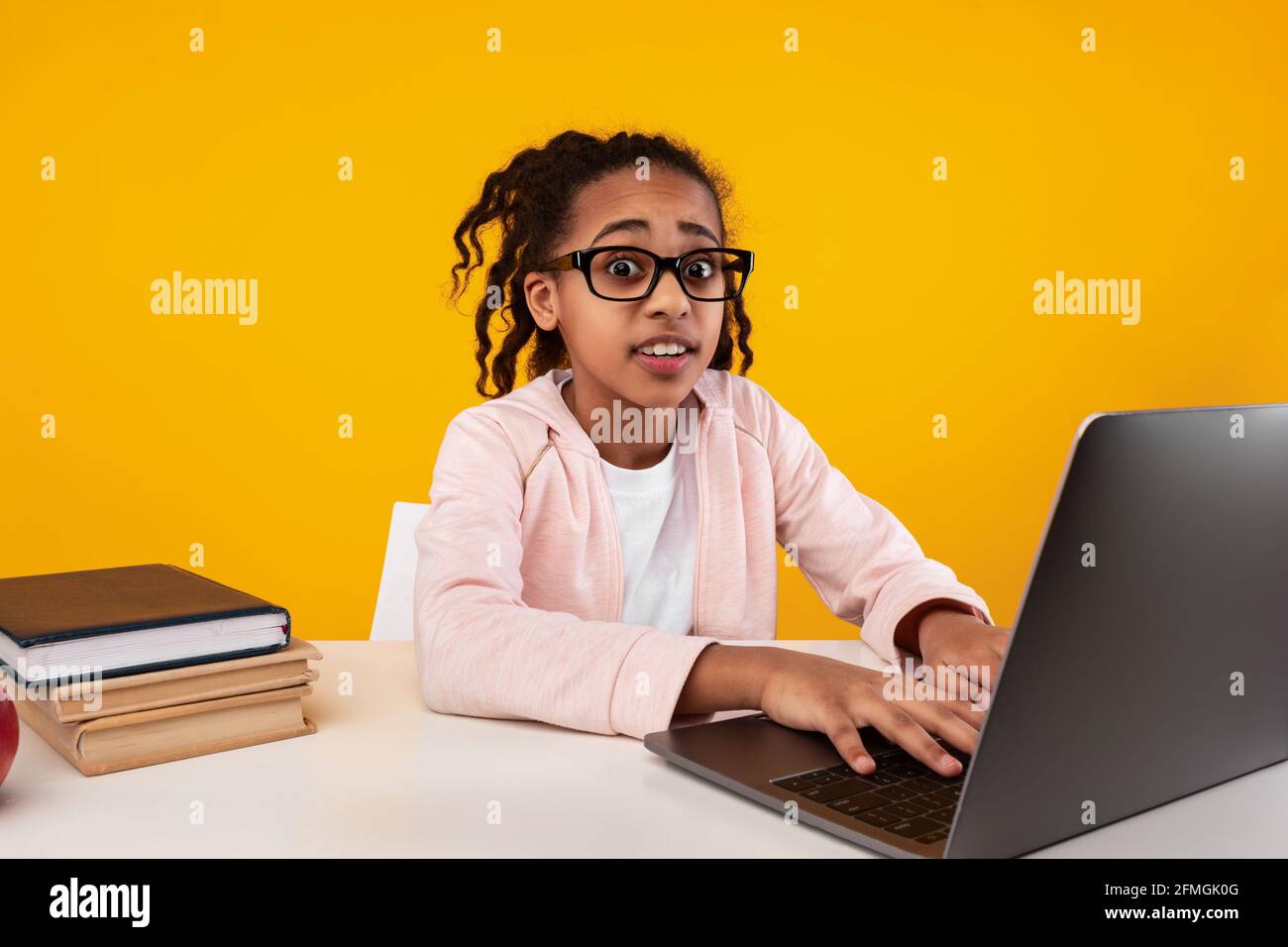 Shocked black girl using laptop looking at camera Stock Photo