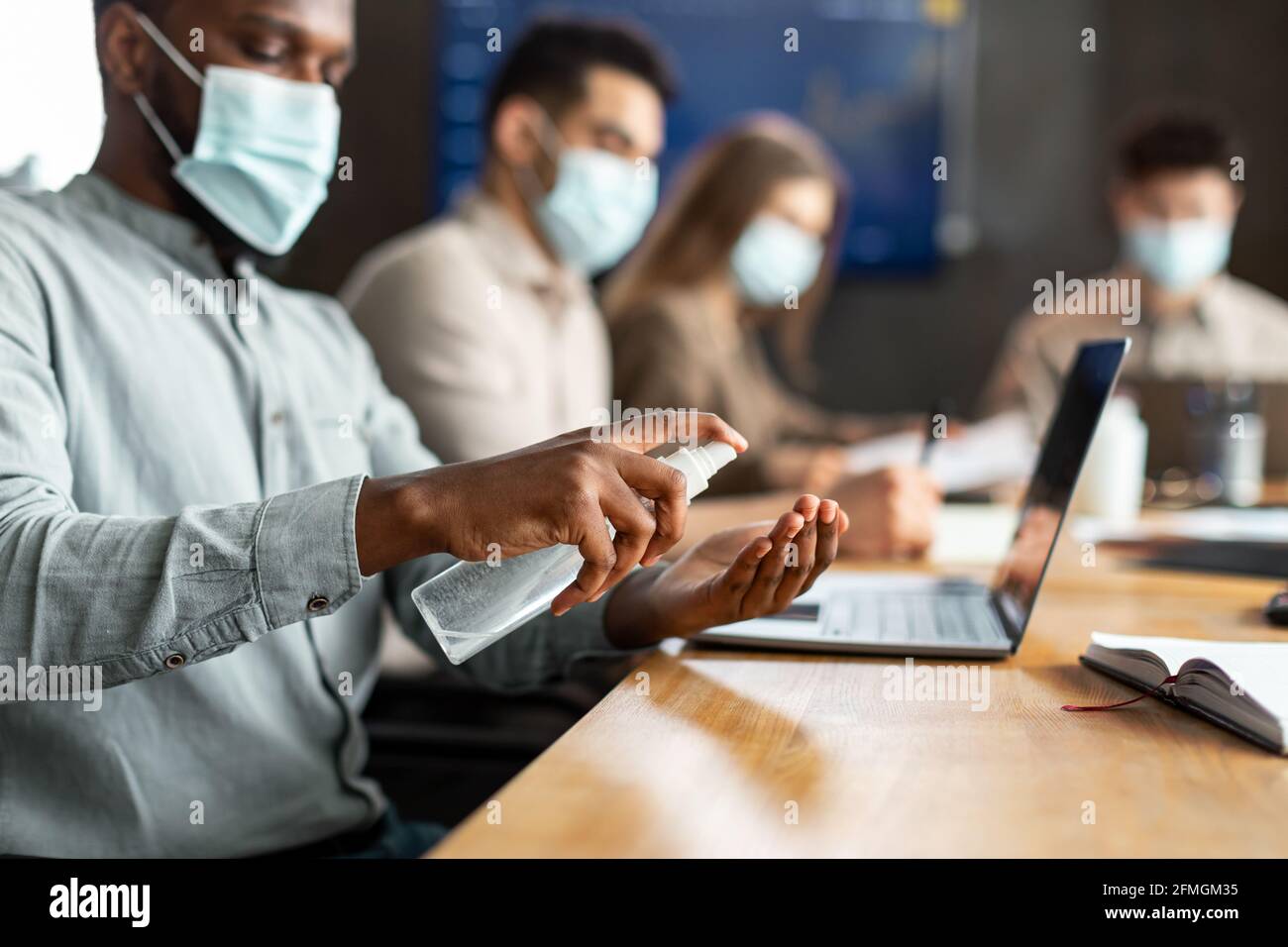 International workers wearing medical masks using sanitizer Stock Photo ...