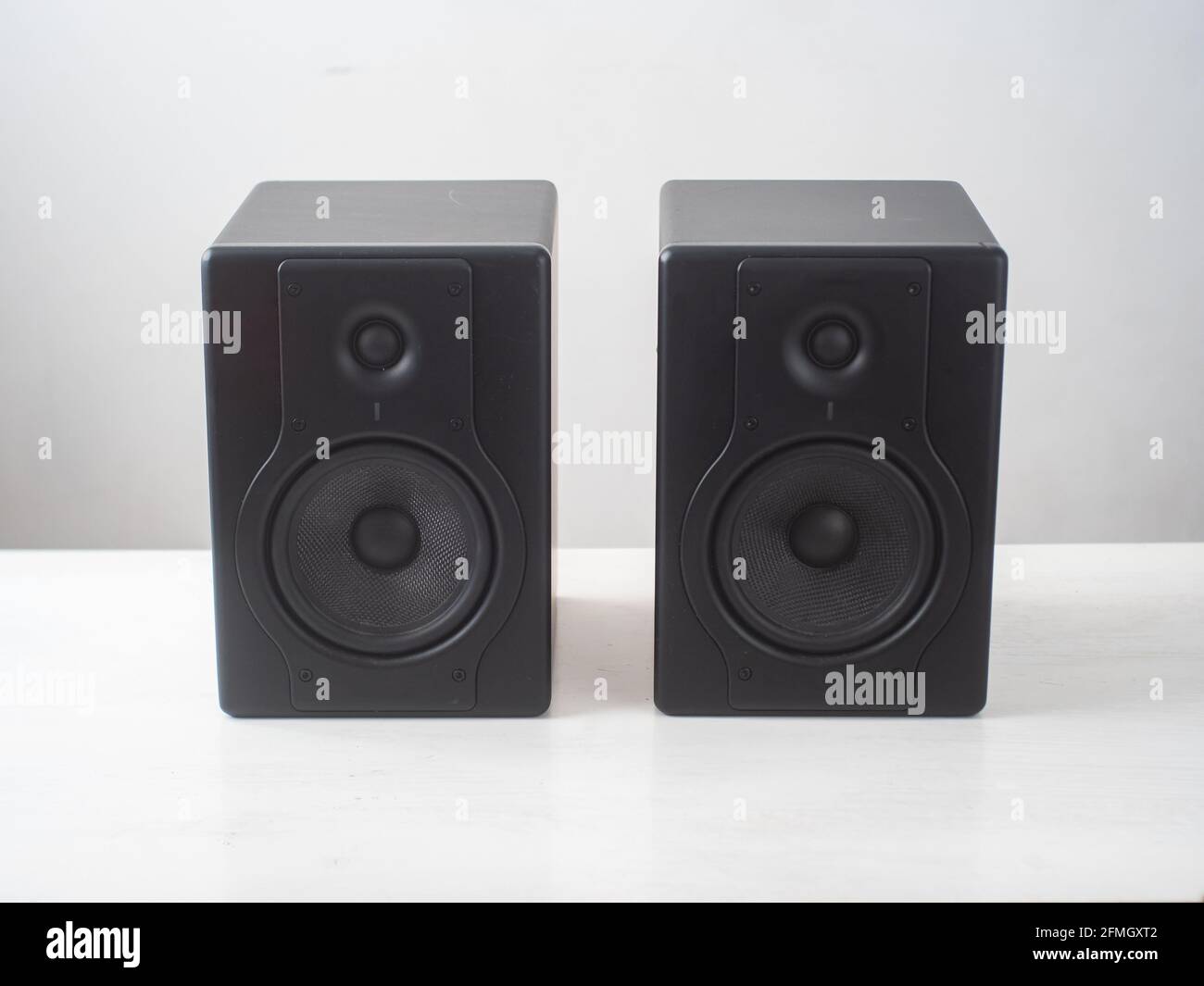Black Pro Studio Speakers against a White and Gray Surface Stock Photo
