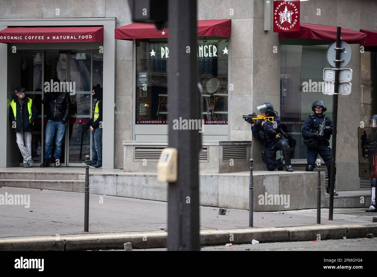 Police officers stand ready during clashes with protesters close to the Arc de Triomphe during the fourth Saturday of national protests by the 'yellow Stock Photo