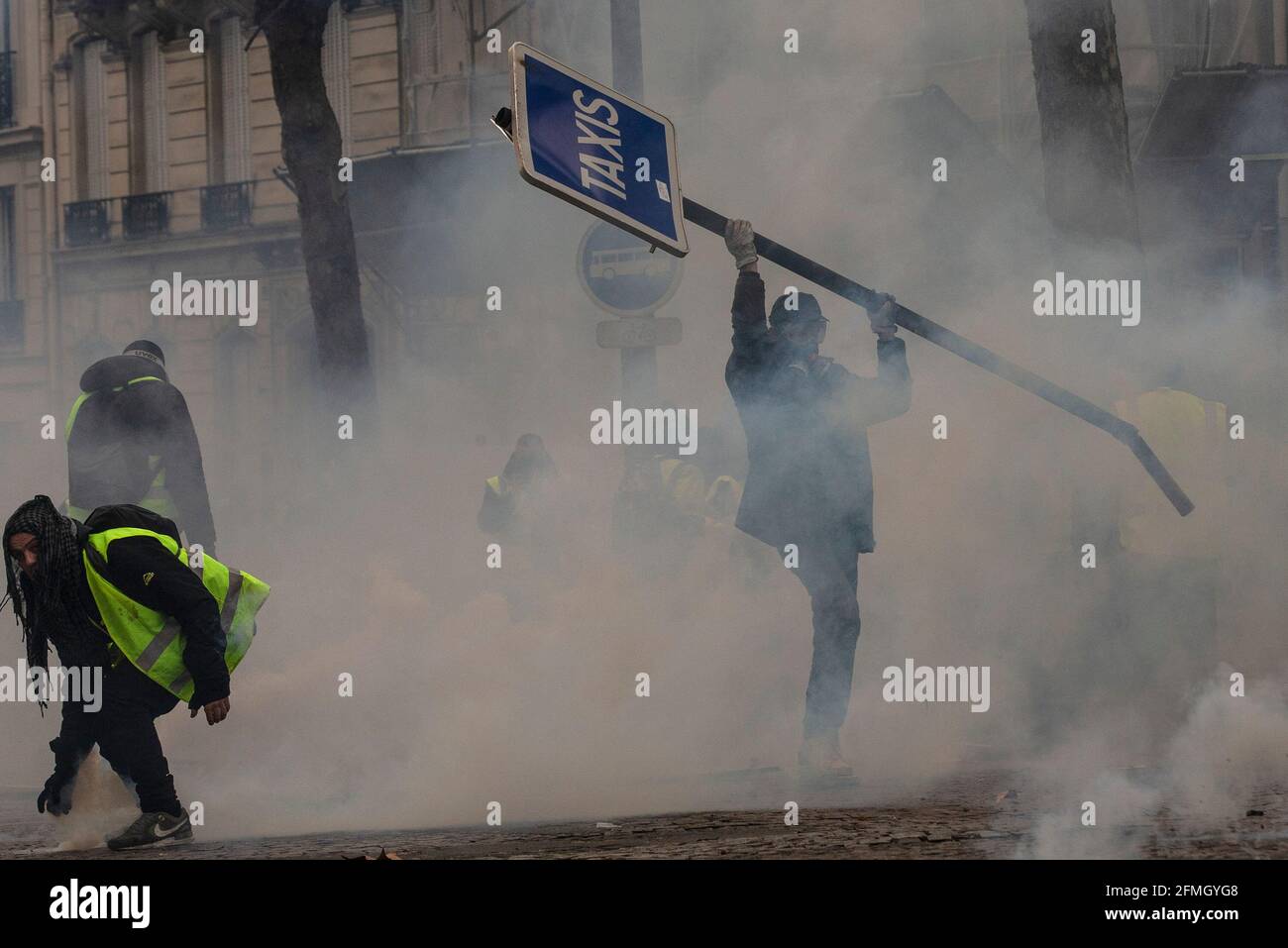 Protesters clash with the police close to the Arc de Triomphe during the fourth Saturday of national protests by the 'yellow vests' movement in the ca Stock Photo