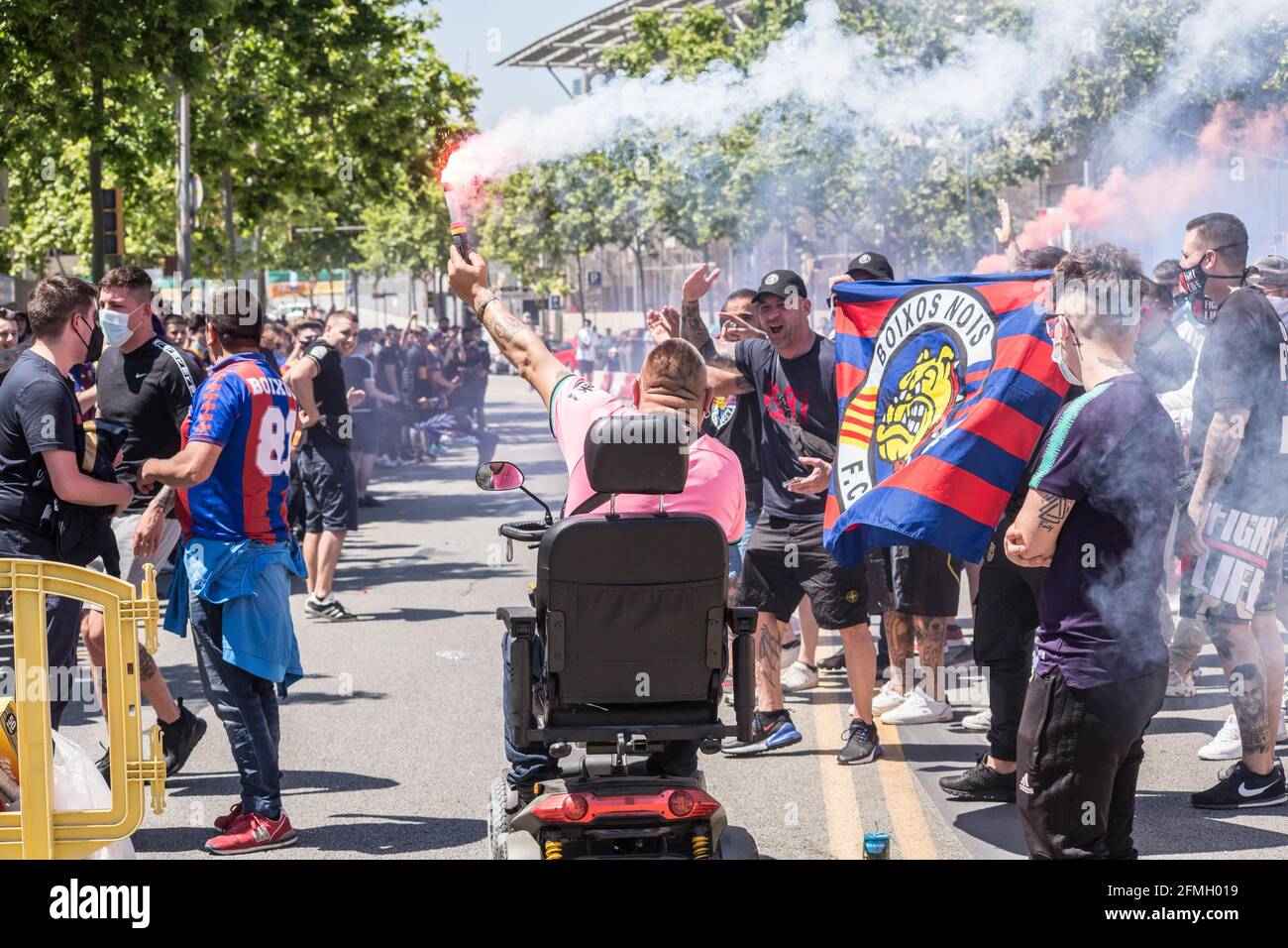 Barcelona, Catalonia, Spain. 8th May, 2021. FC Barcelona fan is seen in an electric wheelchair with a flare.The ultras supporter group of Futbol Club Barcelona, Boixos Nois (Crazy Boys) have gathered outside the Camp Nou stadium to motivate the team before the match against Club Atletico de Madrid for the 35th round of La Liga, the Spanish football league. Barça's victory will put the team, currently in third place, ahead of Atletico de Madrid, which occupies the first position. Credit: Thiago Prudencio/DAX/ZUMA Wire/Alamy Live News Stock Photo
