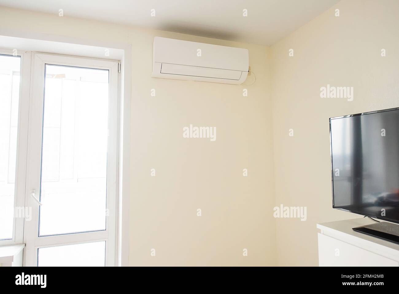 The air conditioner is installed in the corner of the real room next to