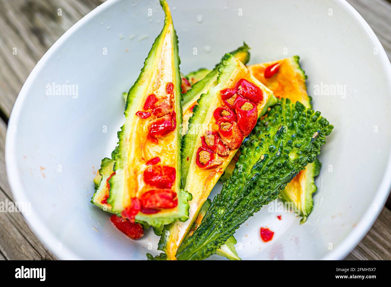 Closeup macro of red bitter melon vegetable seeds coating that tastes