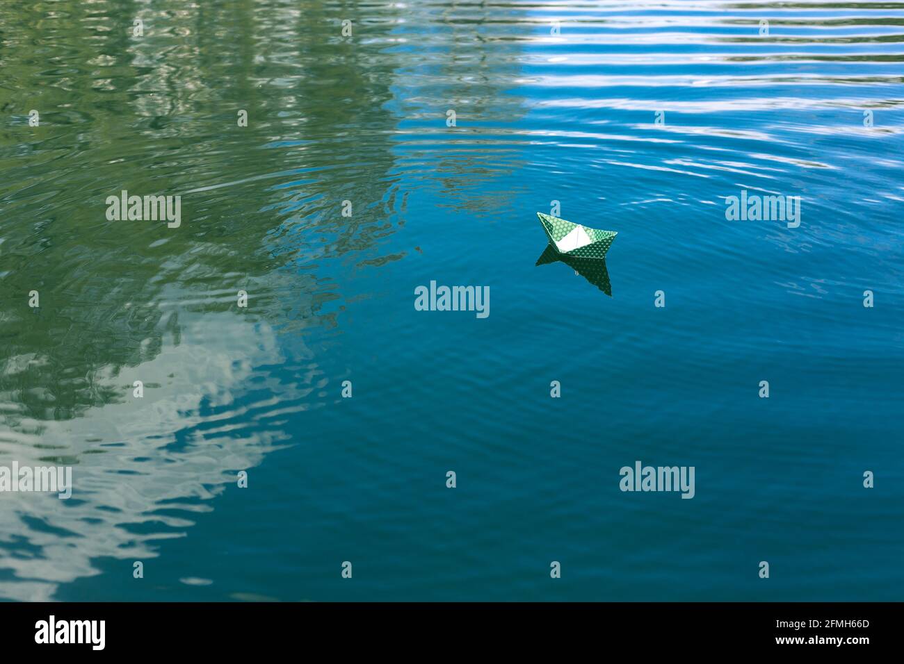 White paper skiffs float on water. Origami Stock Photo - Alamy