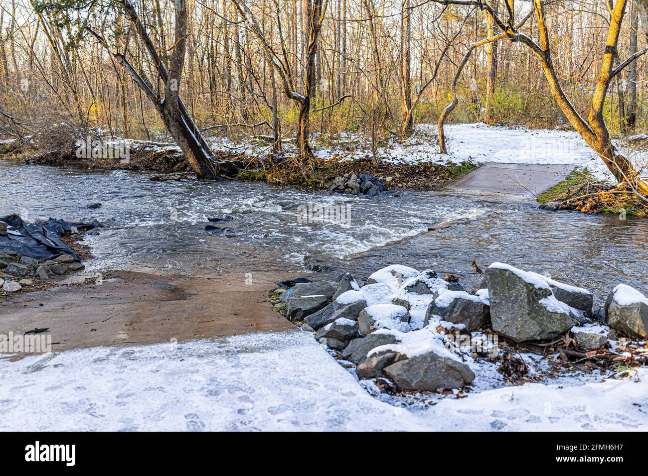 Northern Virginia Fairfax County's Sugarland Run Stream Valley Trail with covered path by water and snow in winter with nobody at sunset Stock Photo