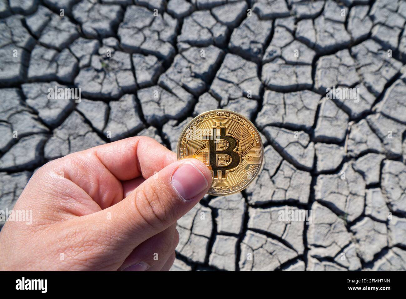 BITCOIN OVER DRY LAND IN HAND SYMBOLIZING GLOBAL WARMING AND CRYPTO MINING  Stock Photo - Alamy