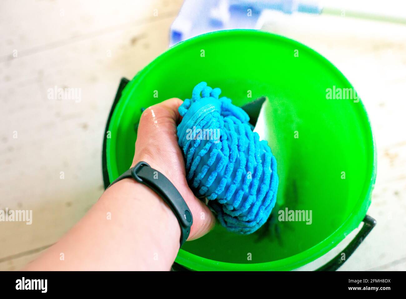 Washing a doormat in a bucket of water. Room cleaning Stock Photo Alamy