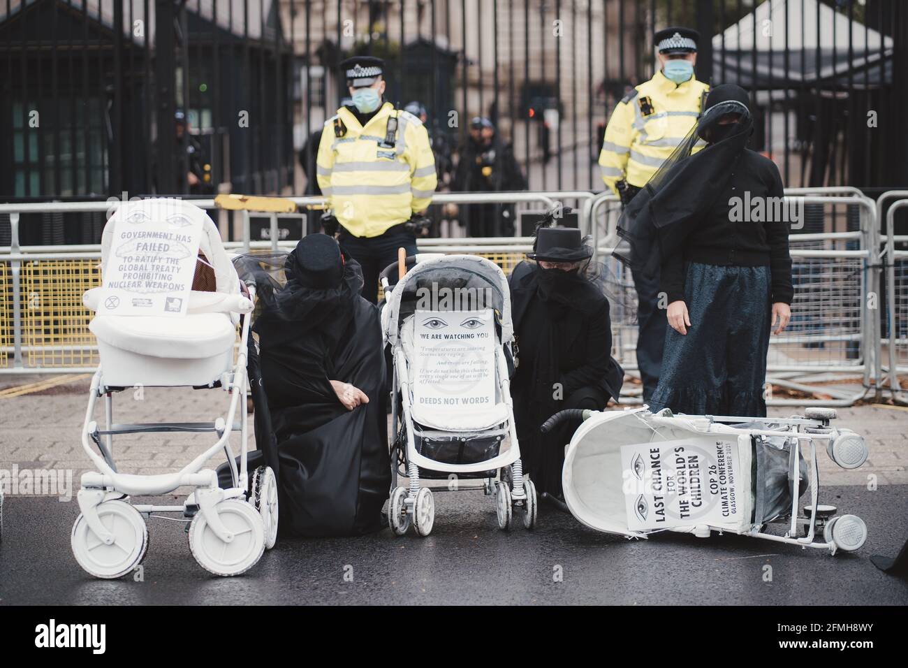 Westminster, London | UK -  2021.05.08: Extinction Rebellion activists kneeling in front of Downing Street with White Baby Prams Stock Photo
