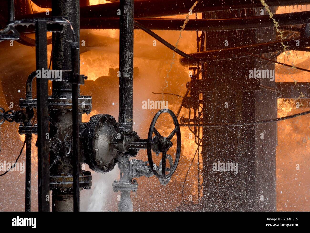 Homs, Syria. 9th May, 2021. Photo taken on May 9, 2021 shows a fire scene in an oil refinery in Syria's central province of Homs. Firefighters succeeded in putting out a fire that erupted in the oil refinery on Sunday morning, SANA news agency reported. Credit: Str/Xinhua/Alamy Live News Stock Photo