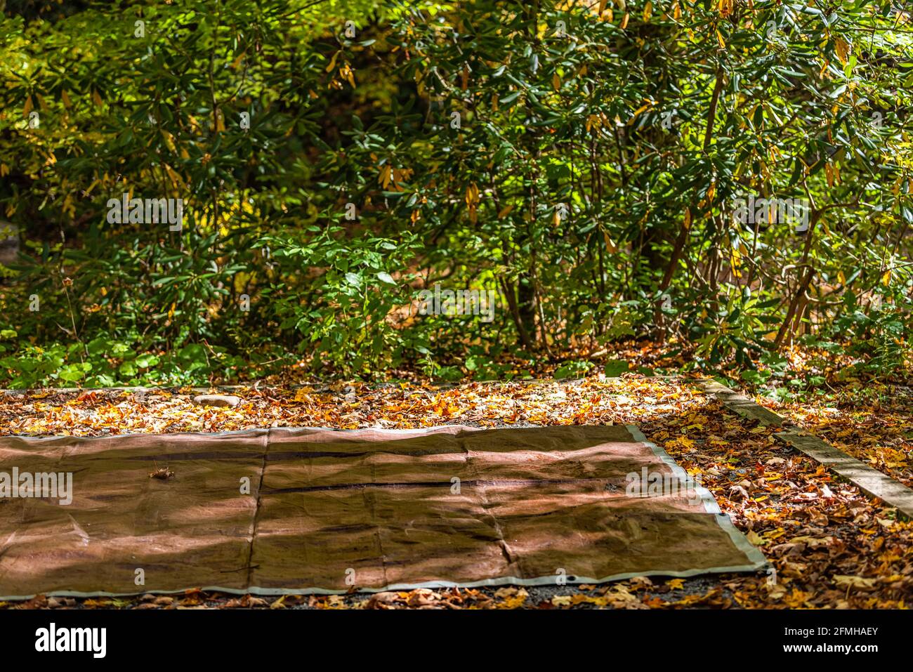 Brown and grey tarpaulin tarp spread as ground sheet cover for