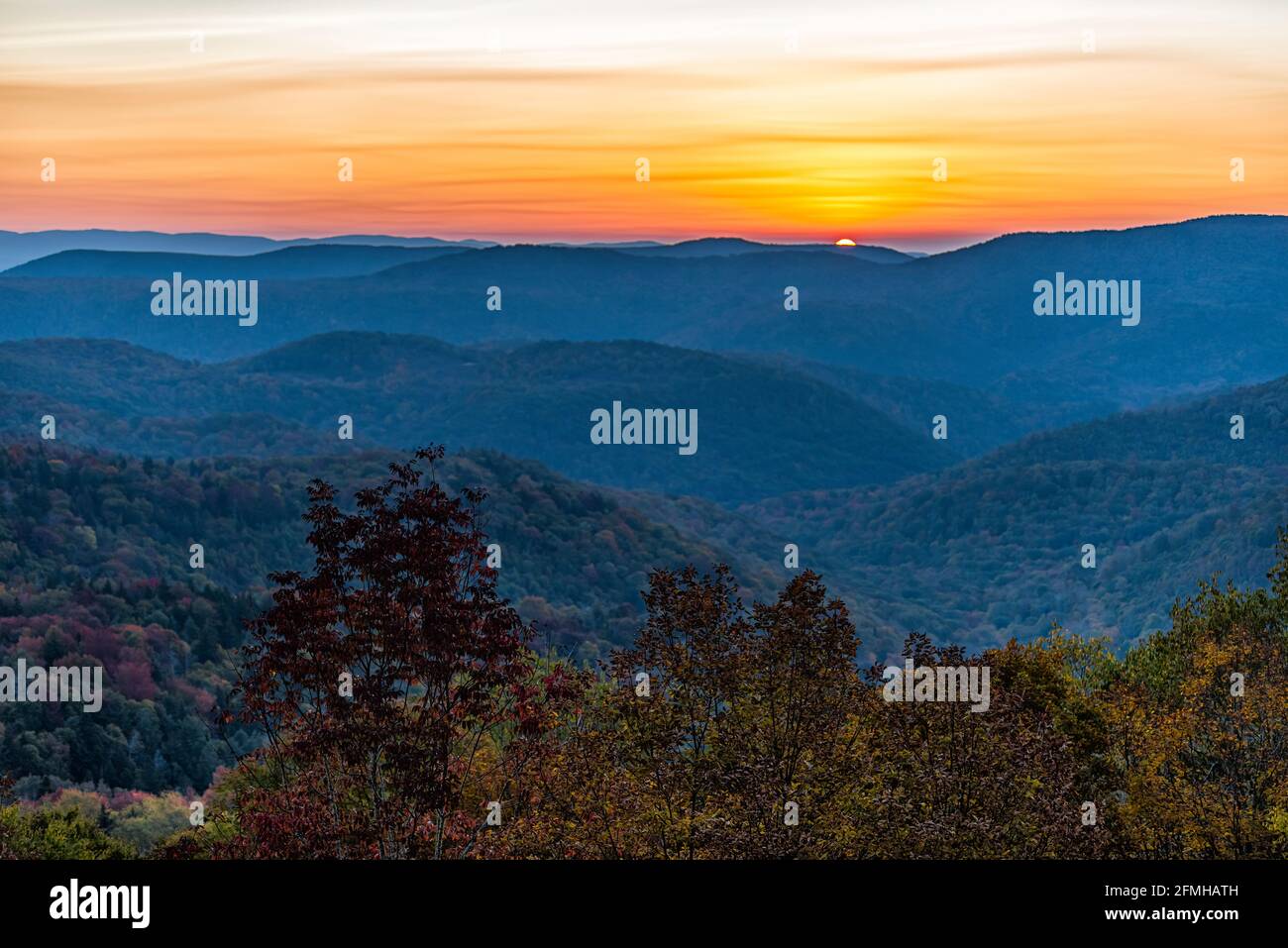 West Virginia Monongahela national forest with sun in Highland Scenic Highway mountains horizon overlook in autumn with colorful tree foliage at morni Stock Photo