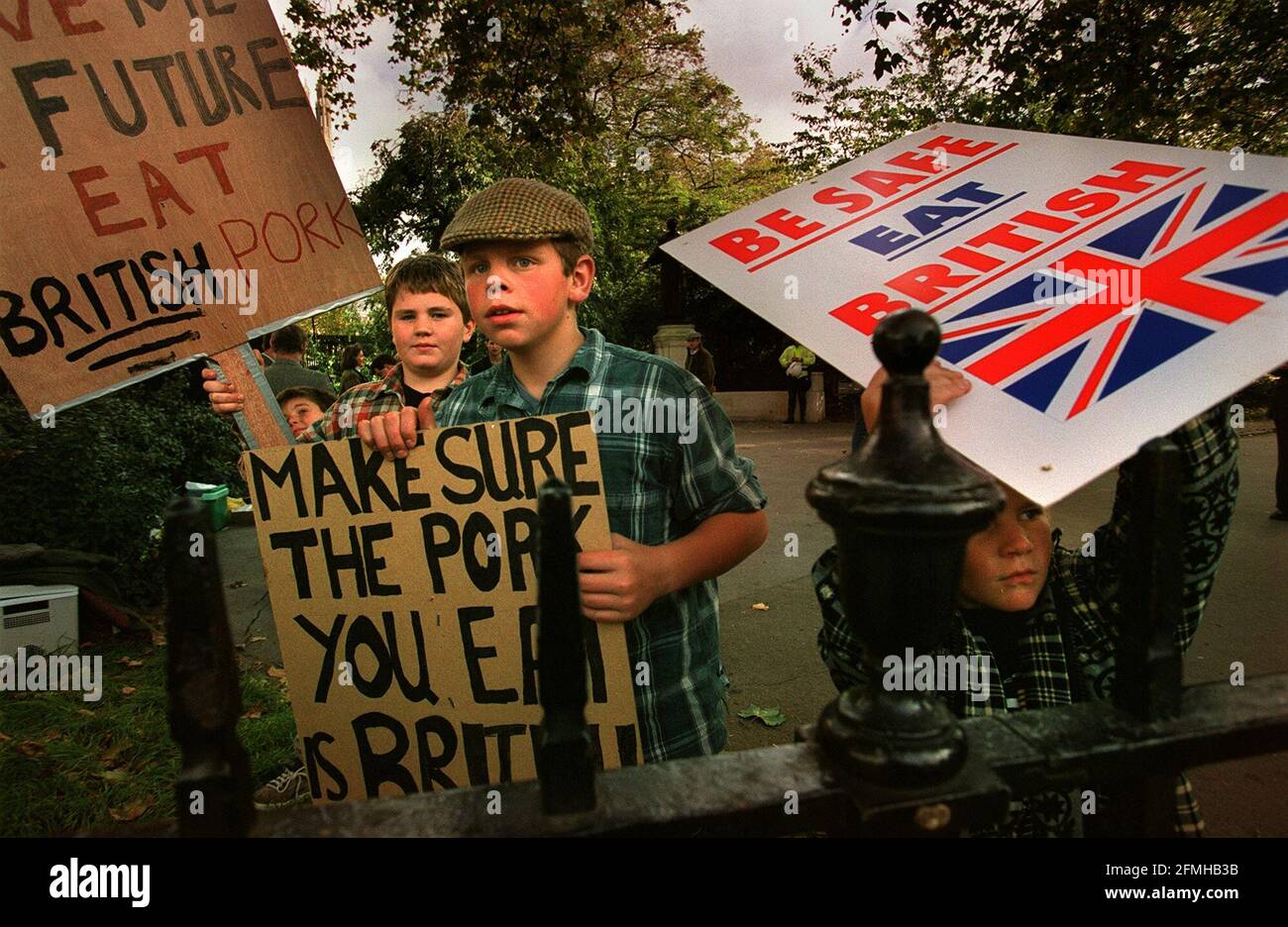 YOUNG BOYS AT A PROTEST OCTOBER1999BY BRITISH PIG FARMERS OUTSIDE THE HOUSE OF COMMONS WHERE THEY WERE GIVING AWAY FREE BACON SANDWICHES Stock Photo