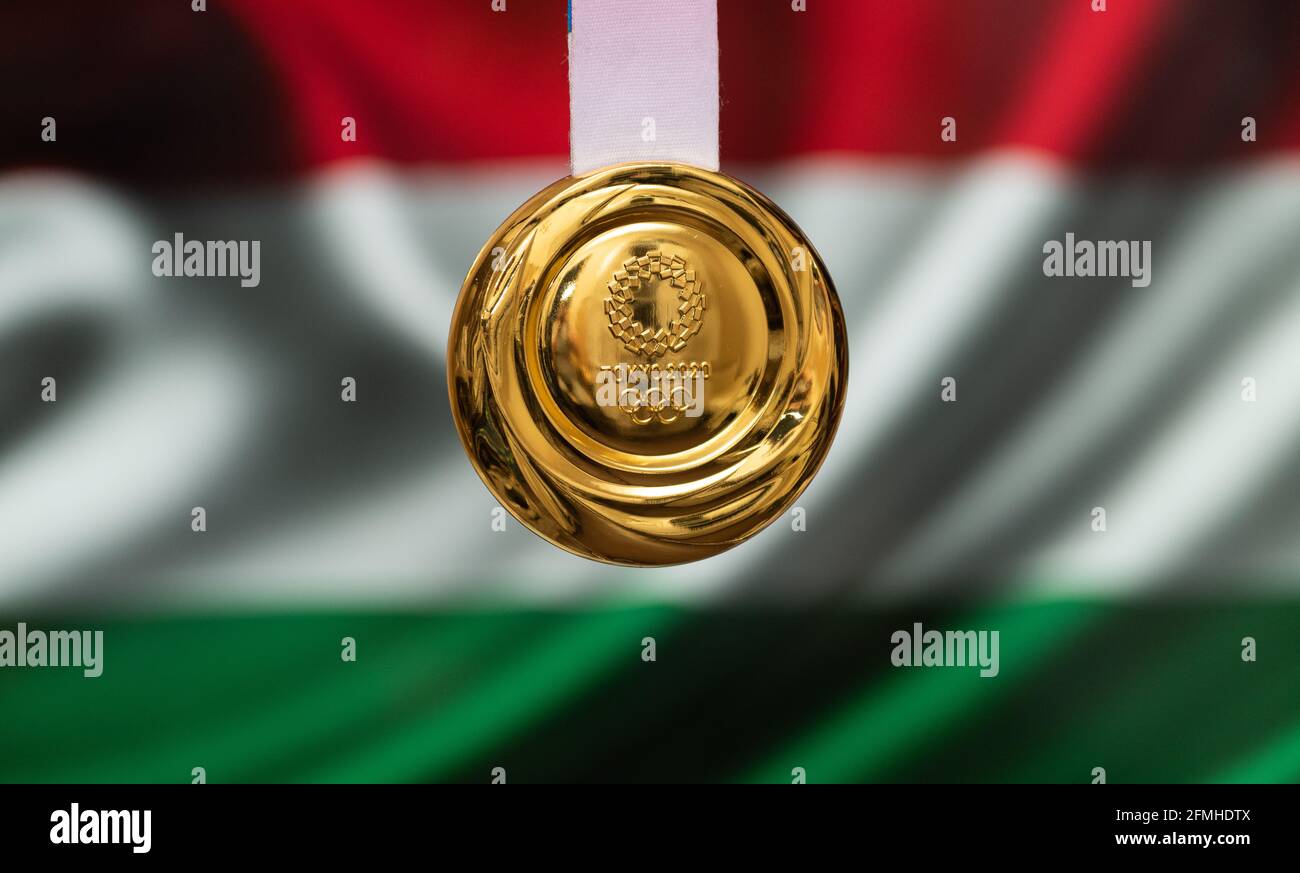April 25, 2021 Tokyo, Japan. Gold medal of the XXXII Summer Olympic Games 2020 in Tokyo on the background of the flag of Hungary. Stock Photo