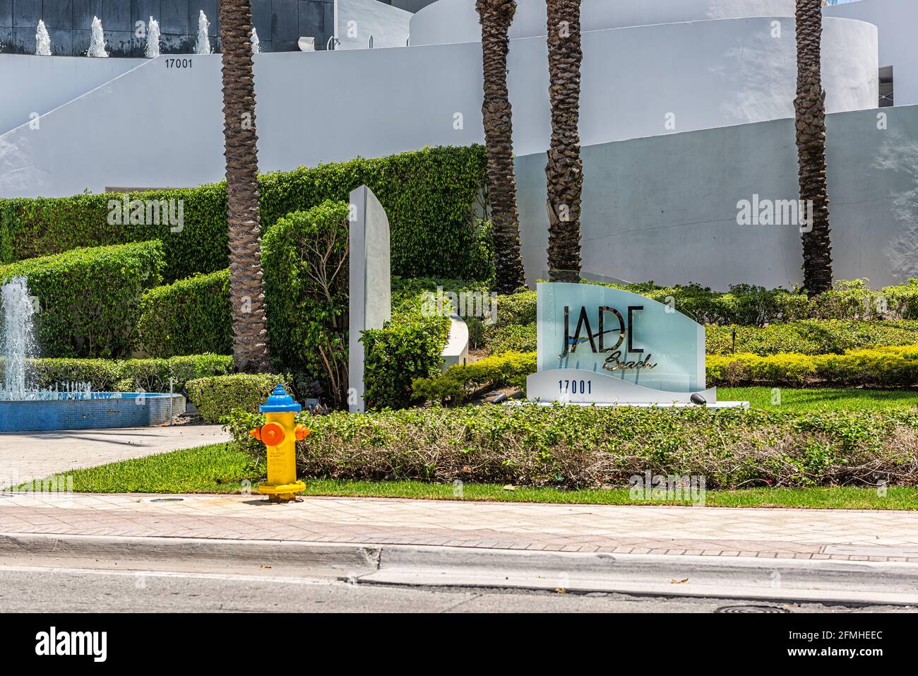 Sunny Isles Beach, USA - May 8, 2018: Jade condominium condo apartment complex building in Miami, Florida with sign, water fountain and sidewalk Stock Photo